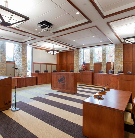 A courtroom with many wooden benches and tables.
